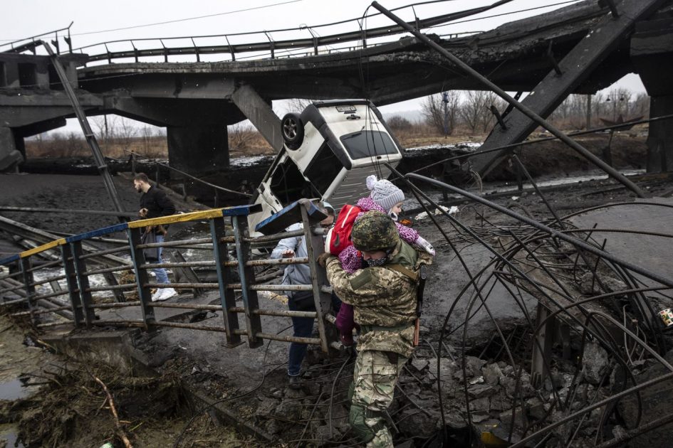 A Ukrainian commander carried a young girl as he helped people flee across a destroyed bridge on the outskirts of Kyiv, Ukraine, on Thursday.HEIDI LEVINE/FTWP